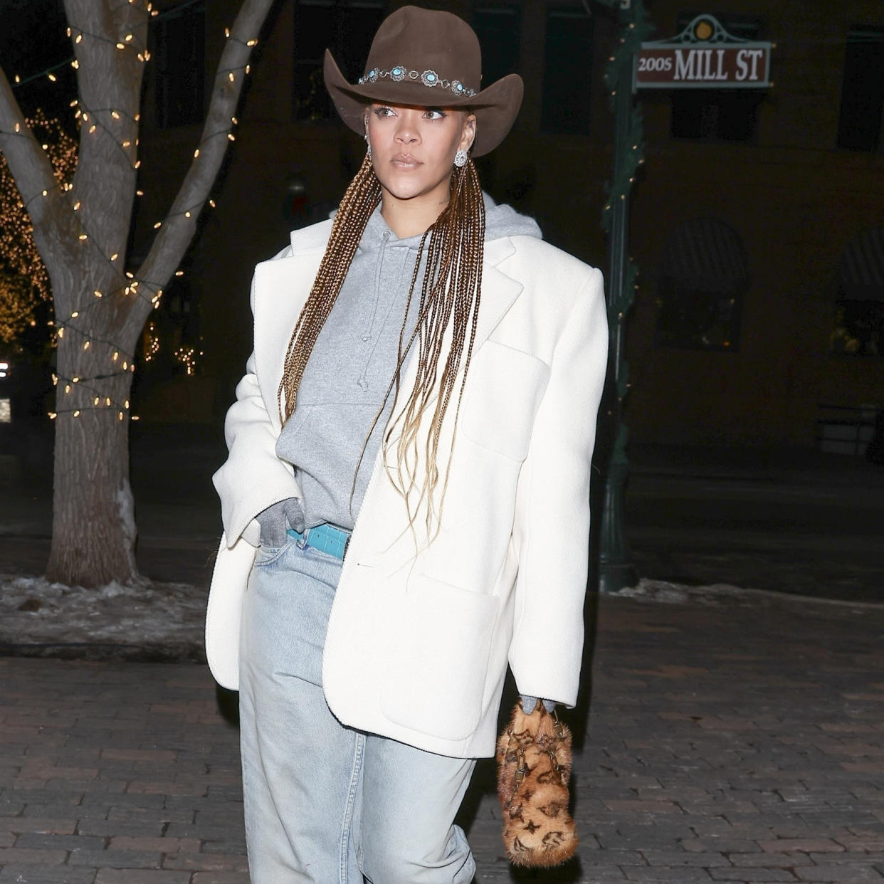  Rihanna wearing a western hat with a sweatshirt and a blazer. 