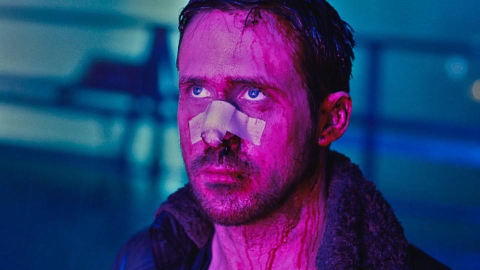  Ryan Gosling looking worse for wear looking up lit by purple light. 