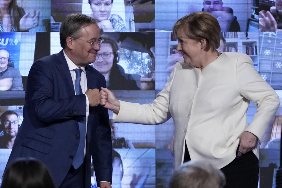 German chancellor Angela Merkel, right, and Christian Democrats candidate Armin Laschet shake hands after a state election campaign in Munich, Germany, Friday, Sept. 24, 2021 two days before the General election on Sunday, Sept. 26, 2021. (AP Photo/Matthias Schrader)