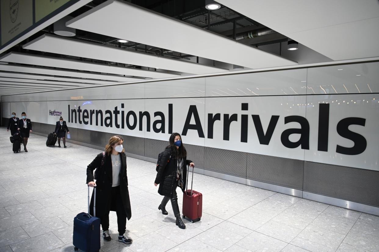 Passengers wearing face masks as a precautionary measure against COVID-19, walk through the arrivals hall after landing at London Heathrow Airport in west London, on January 15, 2021. - International travellers will need to present proof of a negative coronavirus test result in order to be allowed into England, or face a £500 ($685, 564 euros) fine on arrival, from January 18. (Photo by DANIEL LEAL-OLIVAS / AFP) (Photo by DANIEL LEAL-OLIVAS/AFP via Getty Images)