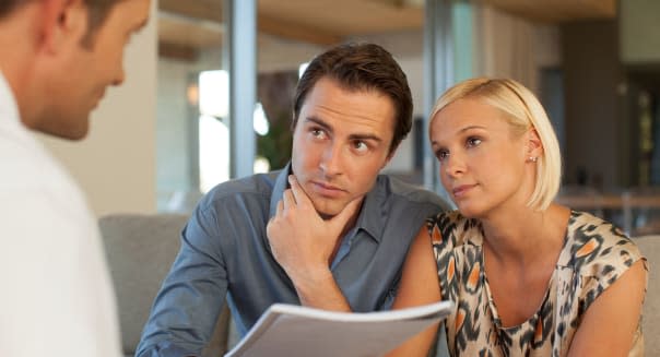 Financial advisor talking to couple on sofa