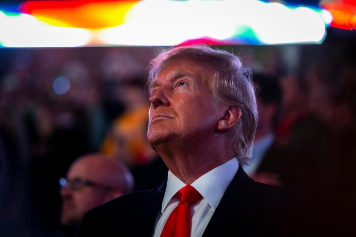 Former President Donald Trump stands for the national anthem in the finals during the sixth session of the NCAA Division I Wrestling Championships, Saturday, March 18, 2023, at BOK Center in Tulsa, Okla.