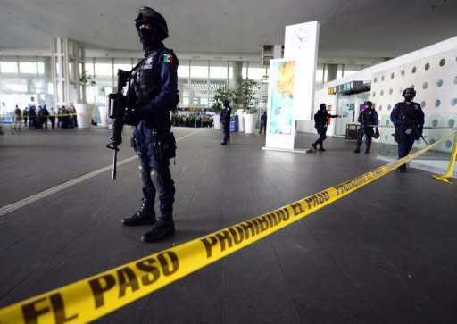 Federal police cordon off an entrance to Benito Juarez international airport Terminal 2, in Mexico City, where three police officers were shot dead on June 25, 2012