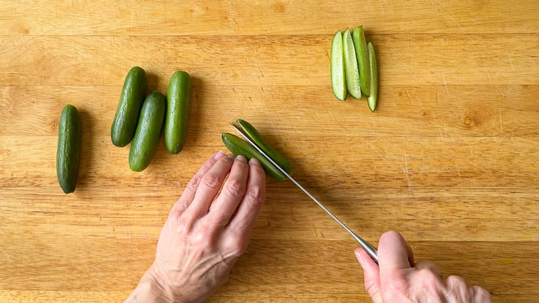 Cutting baby cucumbers on cutting board