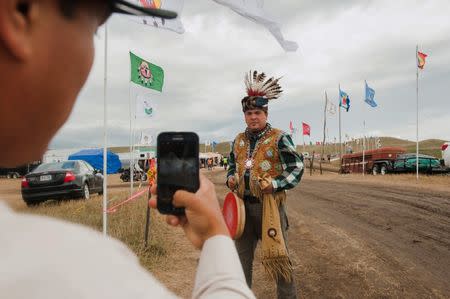 Aaron Makwa Chivis takes a photo of his friend Joe Syette after they travelled from the Saginaw Chippewa Reservation in Mount Pleasant, Michigan to join an encampment near the Standing Rock Sioux reservation in Cannon Ball, North Dakota, September 7, 2016. REUTERS/Andrew Cullen
