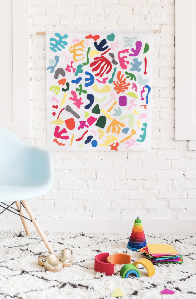 crafts for kids, white board decorated with felt shapes, hanging on the white wall