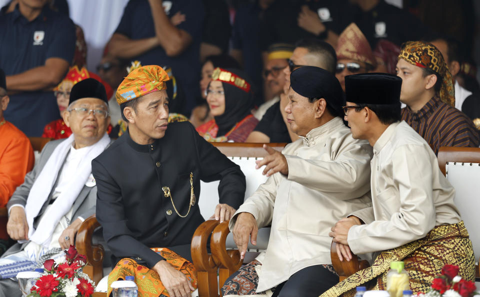 Indonesian President Joko Widodo, second left, and his running mate Ma'ruf Amin, left, and his contender Prabowo Subianto, second right, with his running mate Sandiaga Uno, right, during a ceremony marking the kick off of the campaign period for next year's election in Jakarta, Indonesia, Sunday, Sept. 23, 2018. Indonesia is set to hold its presidential and parliamentary election poll in April 2019.(AP Photo/Tatan Syuflana)