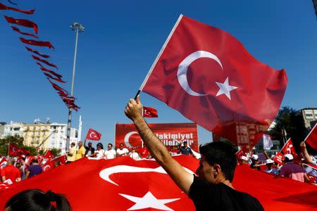 A man waves Turkey's national flag as supporters of various political parties gather in Istanbul's Taksim Square before the Republic and Democracy Rally organised by main opposition Republican People's Party (CHP), Turkey, July 24, 2016. REUTERS/Osman Orsal