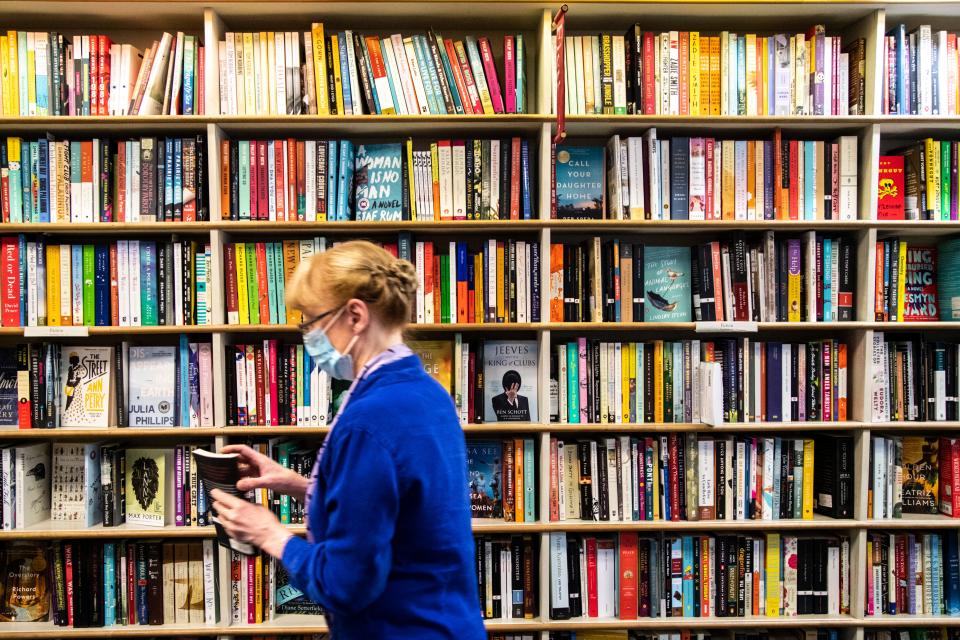 Prairie Lights owner Jan Weissmiller wears a mask while finding a book for a call-in customer amid the novel coronavirus pandemic, Wednesday, Aug. 5, 2020, at Prairie Lights in Iowa City, Iowa. 