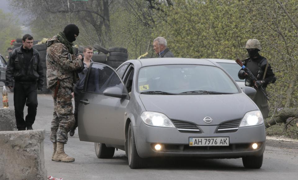 Pro-Russian gunmen control a road after a night fight at the check point which is under the control of pro-Russian activists in the village of Bulbasika near Slovyansk, Ukraine, Sunday, April 20, 2014. At least one person was dead. Pro-Russian insurgents defiantly refused to surrender their weapons or give up government buildings in eastern Ukraine, despite a diplomatic accord reached in Geneva and overtures from the government in Kiev. (AP Photo/Efrem Lukatsky)