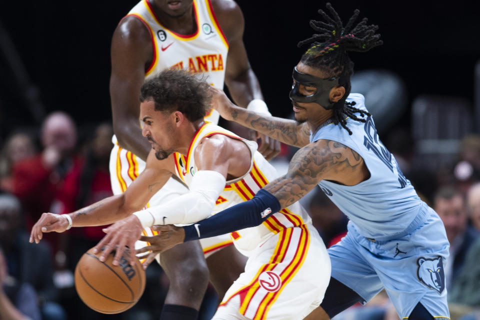 Memphis Grizzlies guard Ja Morant, right, knocks the ball away from Atlanta Hawks guard Trae Young during the first half of an NBA basketball game, Sunday, March 26, 2023, in Atlanta. (AP Photo/Hakim Wright Sr.)