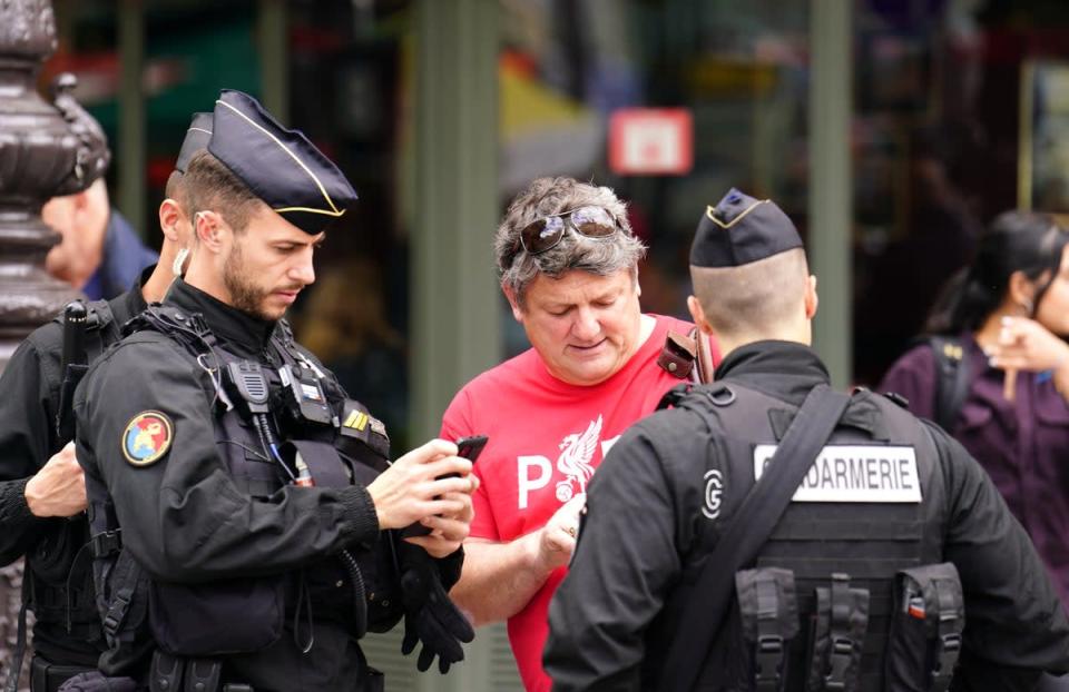 A Liverpool fan receives help from local police in Paris (Adam Davy/PA) (PA Wire)