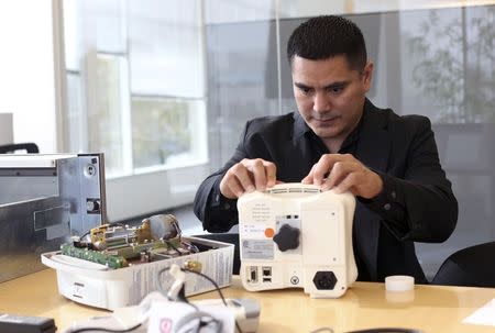 Cybersecurity researcher Billy Rios looks over an EEF brain wave monitor in Redwood City, California October 10, 2014. REUTERS/Robert Galbraith