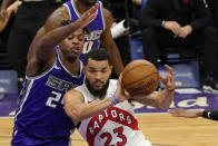 Toronto Raptors guard Fred VanVleet, right, passes the ball as Sacramento Kings guard Buddy Hield defends during the first quarter of an NBA basketball game in Sacramento, Calif., Friday, Jan. 8, 2021. (AP Photo/Rich Pedroncelli)