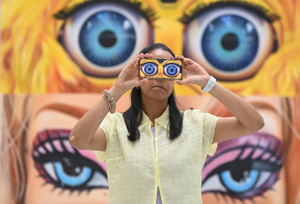 A gallery worker poses with work by artist Elinor Stanley during a press preview of The RA Schools Show 2023 at the Royal Academy of Arts in London (EPA)