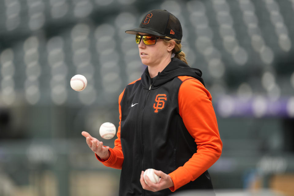 San Francisco Giants major league assistant coach Alyssa Nakken juggles baseballs as players warm up before a baseball game against the Colorado Rockies Tuesday, May 17, 2022, in Denver. (AP Photo/David Zalubowski)