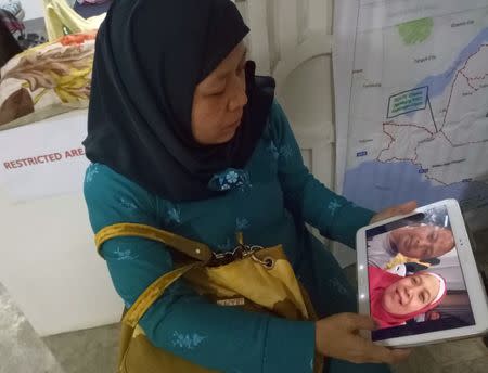 Carmalia Baunto, 42, shows an image of herself and her husband, Nixon Baunto, who is trapped inside the besieged town of Marawi City, Philippines June 21, 2017. Picture taken June 21, 2017. REUTERS/Simon Lewis