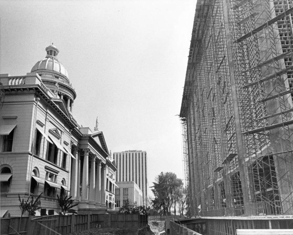 An April 1965 photo shows Fresno County’s 1875-vintage courthouse, left, and its mid-century modern replacement under construction in downtown Fresno’s Courthouse Park.