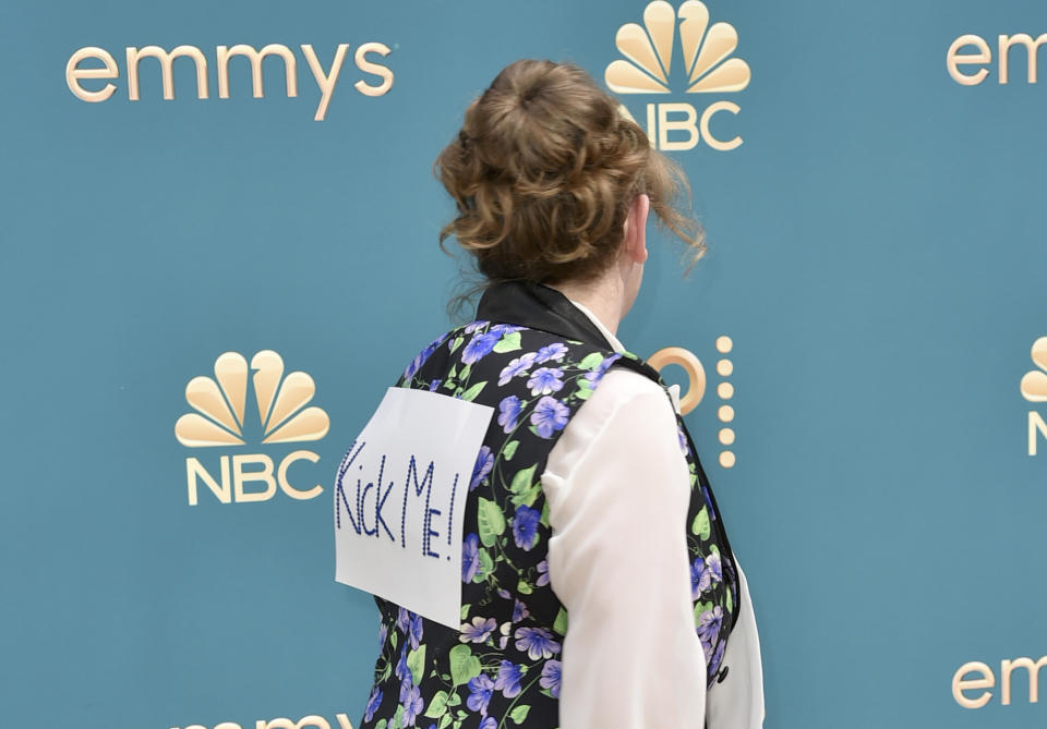 Emily Heller arrives with a kick me sign on her back at the 74th Primetime Emmy Awards on Monday, Sept. 12, 2022, at the Microsoft Theater in Los Angeles. (Photo by Richard Shotwell/Invision/AP)