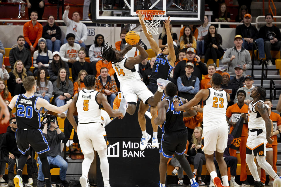 BYU guard Trey Stewart (1) defends as Oklahoma State guard Jamyron Keller (14) shoots in the first half of the NCAA college basketball game, Saturday, Feb. 17, 2024, in Stillwater, Okla. (AP Photo/Mitch Alcala)