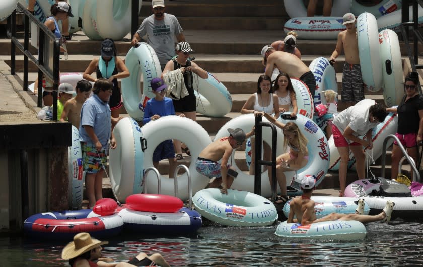 Tubers prepare to float the Comal River despite the recent spike in COVID-19 cases, Thursday, June 25, 2020, in New Braunfels, Texas. Texas Gov. Greg Abbott said Wednesday that the state is facing a "massive outbreak" in the coronavirus pandemic and that some new local restrictions may be needed to protect hospital space for new patients. (AP Photo/Eric Gay)