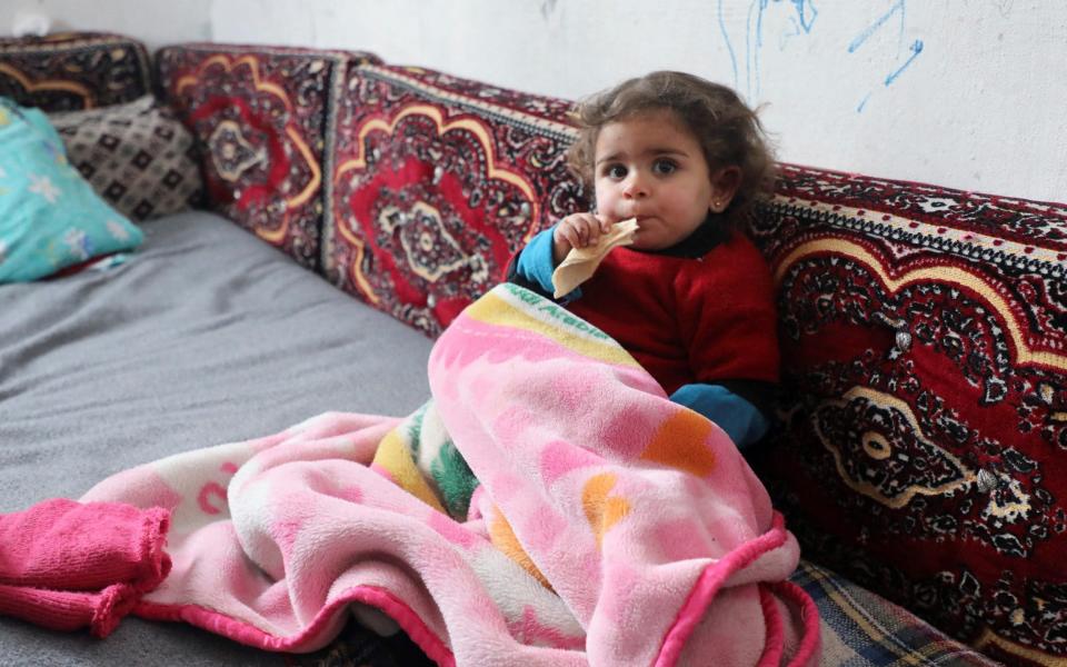 Raghad Ismail, the Syrian toddler who was rescued from rubble of a collapsed building following an earthquake, sits at her uncle's home - Reuters