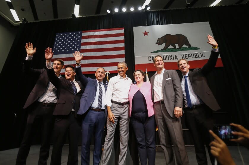 Former President Barack Obama, center, with congressional candidates, from left, Josh Harder, TJ Cox, Gil Cisneros, Katie Porter, Harley Rouda and Mike Levin wave to supporters as Obama campaigns in support of California congressional candidates, Saturday, Sept. 8, 2018, in Anaheim, Calif. (AP Photo/Ringo H.W. Chiu)