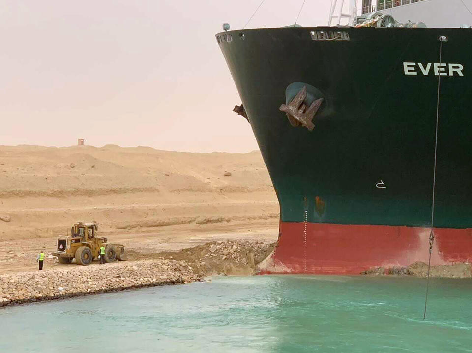 En esta imagen difundida por la Autoridad del Canal de Suez, un carguero llamado Ever Green se ve con la proa encallada en el muro del canal, el miércoles 24 de marzo de 2021, tras quedarse atravesado y bloquear el Canal de Suez, en Egipto, cortando un paso crucial para el tráfico global de mercancías.  (Autoridad del Canal de Suez via AP)