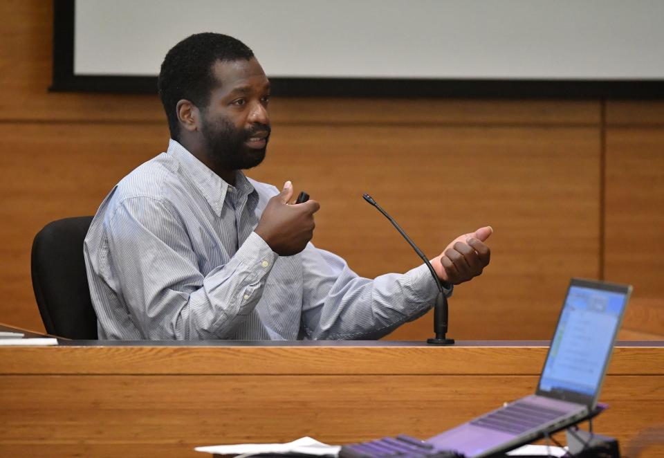 During his testimony Wednesday, Jamaine Brown demonstrates how his brother, Tyjuan Williams, held the rifle when he shot Amber Woods. Brown's other brother, Ralph Williams, is on trial this week in Manatee County for first degree murder in the 2006 death of his girlfriend, Amber Woods.