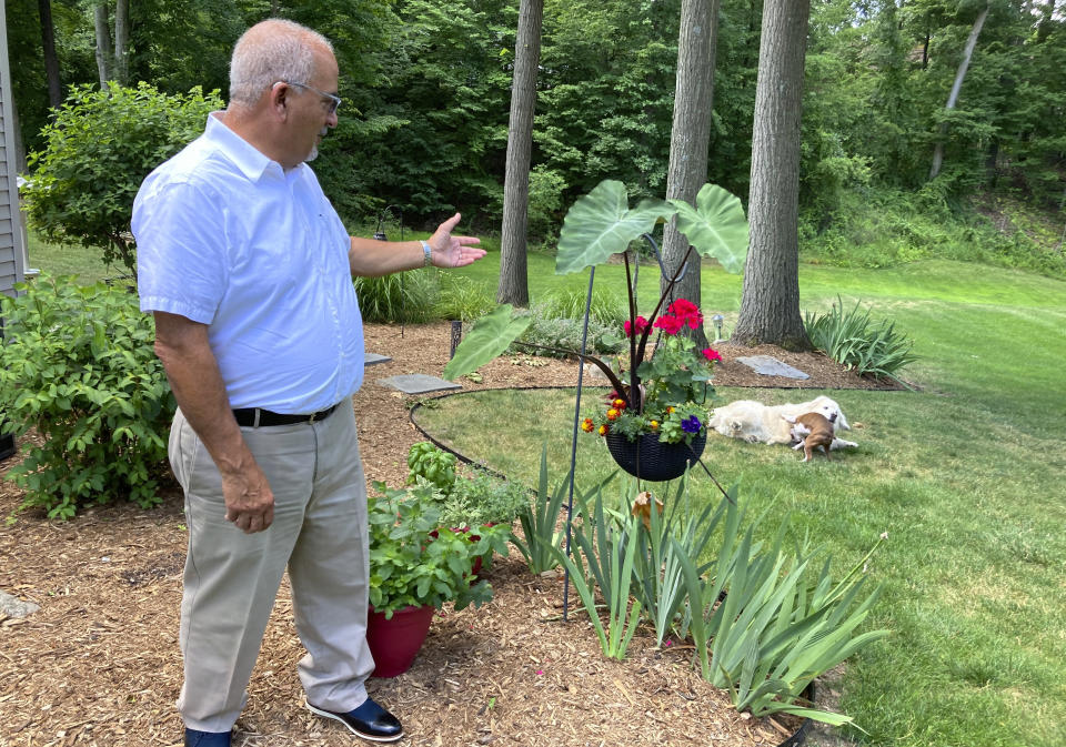 Marty Marino of Michigan's Cascade Township looks over his yard following an essential oil insecticide spray treatment by a Mosquito Joe crew on July 20, 2022. “If you like to be outside, it certainly makes it more pleasant not to be swatting mosquitos and worrying about all the issues,” Marino said. (AP Photo/John Flesher)