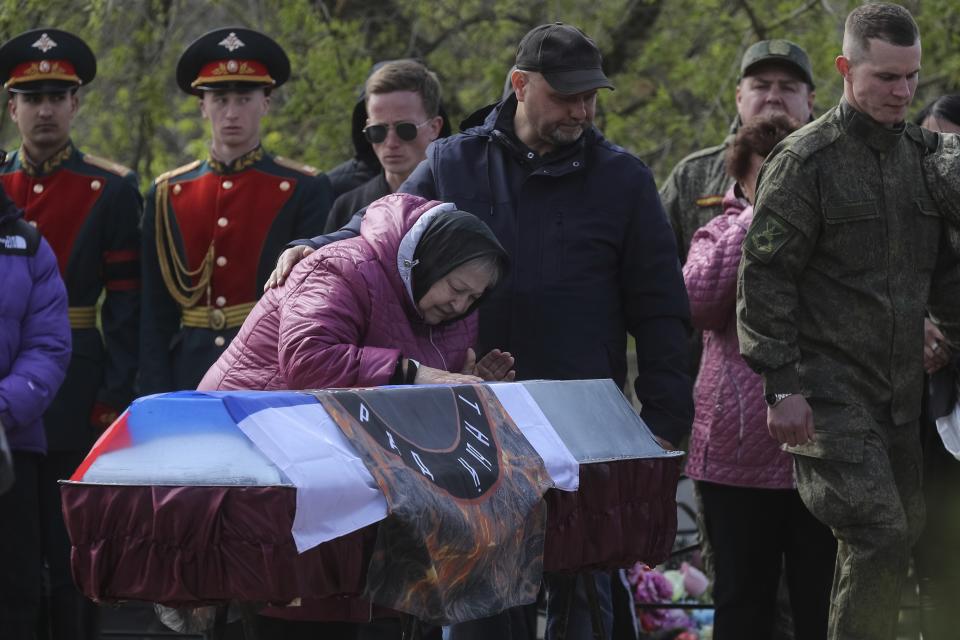 FILE - A relative of Shashkov Savely, a volunteer of detachment "Immortal Stalingrad" in the Russian Army, who was killed during a Russian special military operation in Ukraine, pays her last respect during his farewell ceremony at a cemetery in Krasnoslobodsk, Volgograd region, Russia, Saturday, April 15, 2023. Nearly 50,000 Russian soldiers have died in the war in Ukraine, according to the first independent statistical analysis of Russia’s war dead. (AP Photo, File)
