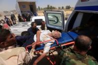 Iraqi soldiers carry a displaced man, who collapsed in exhaustion after fleeing from Mosul, Iraq, June 29, 2017. REUTERS/Alaa Al-Marjani