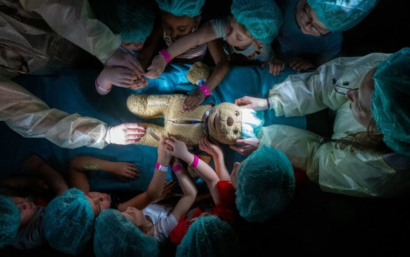Medical students from the University of Halle operate on a teddy bear together with children from the 