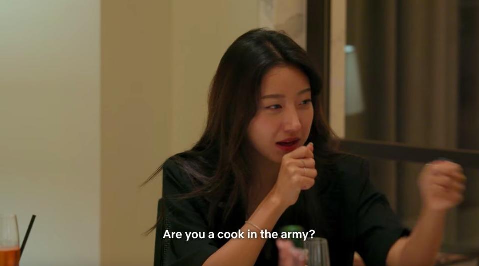 Yea-won holds out her hand as a microphone to Jun-sik and asks "are you a cook in the army?"