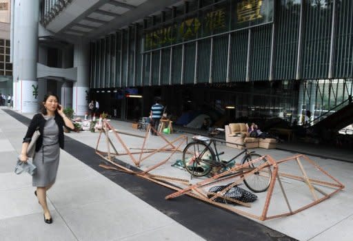 A pedestrian walks past a display by the anti-capitalist Occupy movement in Hong Kong, outside the HSBC building in Hong Kong in June 2012. The camp sprouted at the landmark HSBC tower in central Hong Kong 10 months ago, weeks after thousands of people pitched tents in New York's Zuccotti Park demanding an overhaul of the rules of global capitalism