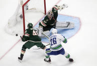 Minnesota Wild goalie Alex Stalock (32) makes a save as teammate Jared Spurgeon (46) and Vancouver Canucks' Antoine Roussel (26) go for the rebound during second-period NHL hockey game action in Edmonton, Alberta, Thursday, Aug. 6, 2020. (Jason Franson/The Canadian Press via AP)