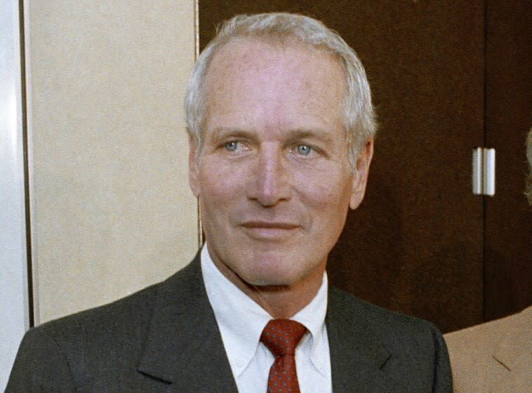 A man with white hair wearing a dark suit