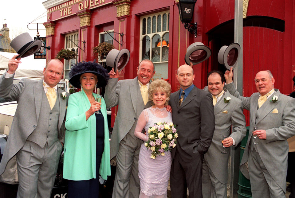 EastEnders stars Barbara Windsor (who plays bride 'Peggy Mitchell') and Mike Reid (groom 'Frank Butcher', third from left), with co-stars during a photocall outside the Queen Vic pub at London's Elstree studios, where their on-screen wedding reception was filmed.   * With fellow actors (l-r) Steve McFadden (Phil), Pam St Clement (Pat), Ross Kemp (Grant), Shaun Williamson (Barry) and Tony Caunter (Roy).   (Photo by John Stillwell - PA Images/PA Images via Getty Images)