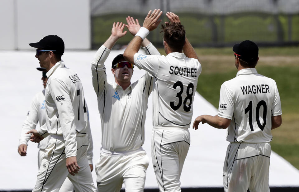 New Zealand's Tim Southee is congratulated by teammates after dismissing England's Ollie Pope during play on day two of the first cricket test between England and New Zealand at Bay Oval in Mount Maunganui, New Zealand, Friday, Nov. 22, 2019. (AP Photo/Mark Baker)