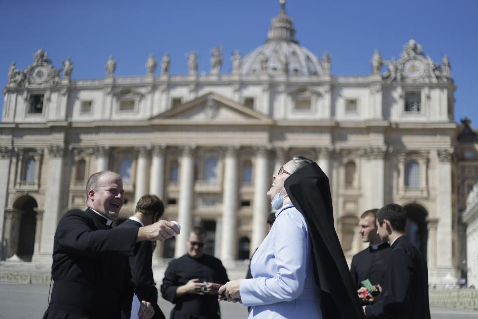 A priest and a nun laugh as they wait for Pope Francis to recite the Angelus noon prayer, in St. Peter's Square at the Vatican, Sunday, Sept. 6, 2020. (AP Photo/Gregorio Borgia)