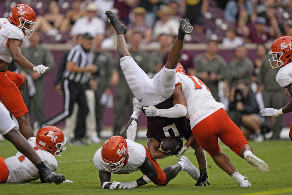 Texas A&M wide receiver Ainias Smith (0) is flipped by Sam Houston State defensive back Darrel Hawkins-Williams, left, and linebacker Kavian Gaither (14) during the second half of an NCAA college football game Saturday, Sept. 3, 2022, in College Station, Texas. (AP Photo/David J. Phillip)