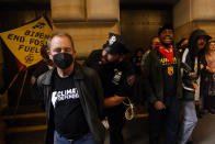 Climate activists are arrested as they blockade the Federal Reserve Bank of New York to call for an end to the use of fossil fuels, Monday, Sept. 18, 2023, in New York. (AP Photo/Jason DeCrow)