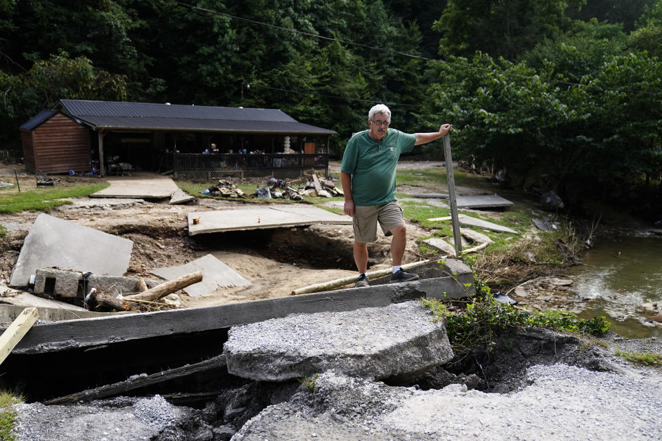 Douglas Maggard, 63, stands next to the bridge leading to his daughter home that was destroyed during massive flooding, on Thursday, Aug. 4, 2022, in Chavies, Ky. Maggard says he called his daughter and told her to leave right before the water rushed in destroying the bridge. (AP Photo/Brynn Anderson)