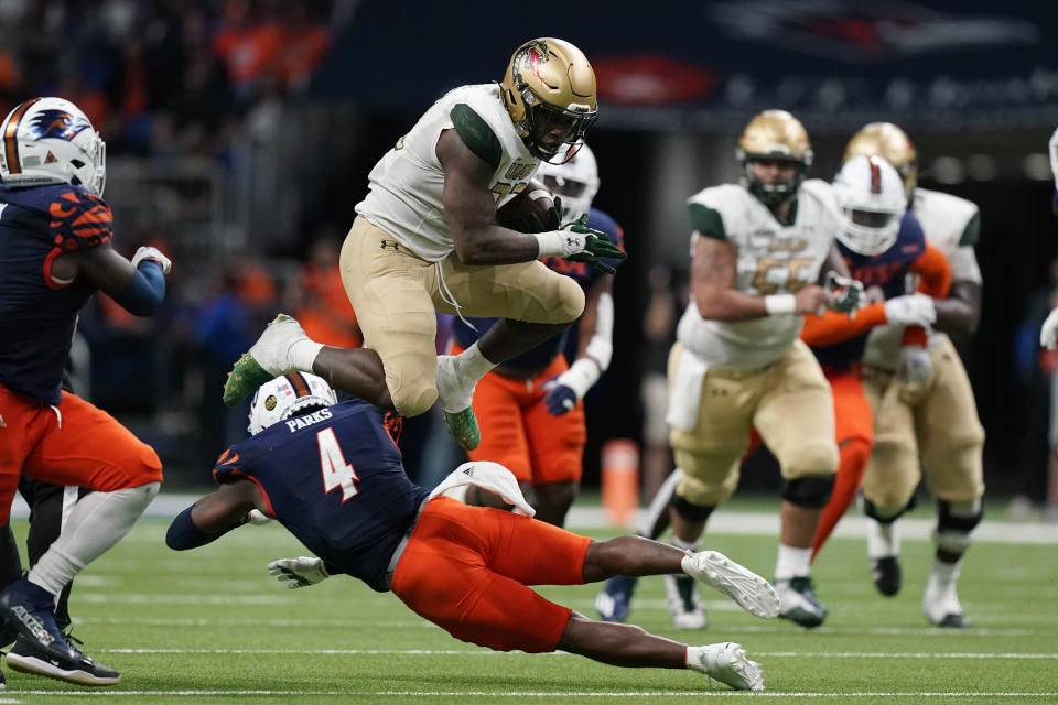 UAB running back DeWayne McBride (22) is upended by UTSA safety Antonio Parks (4) during the second half of an NCAA college football game, Saturday, Nov. 20, 2021, in San Antonio. (AP Photo/Eric Gay)