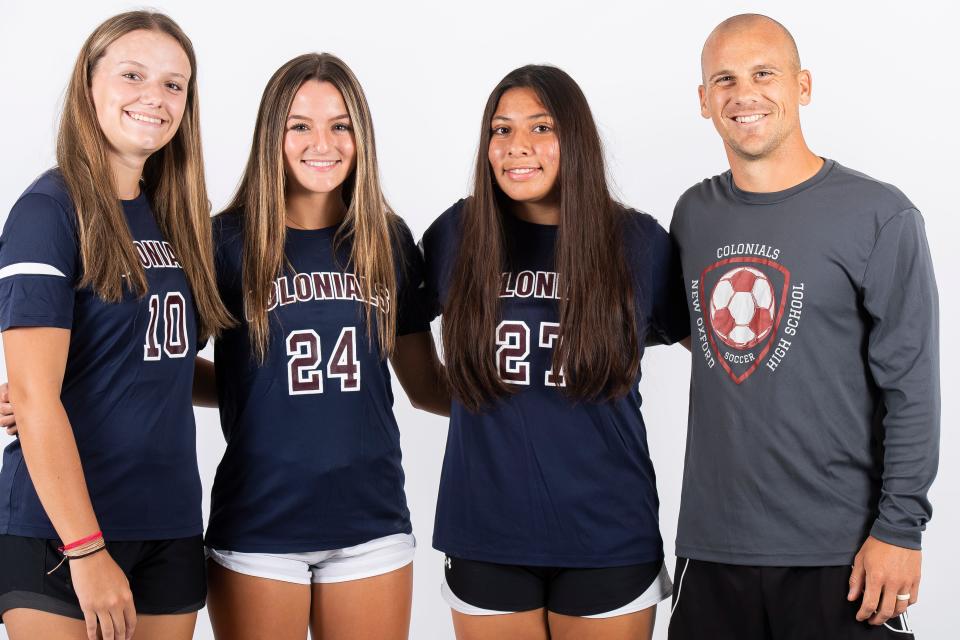 New Oxford soccer players  Camryn Miller (10), Wrena Wentz (24) and Miranda Garcia (27) pose for a photo with head coach David Shaffer during YAIAA fall sports media day on Thursday, August 3, 2023, in York.