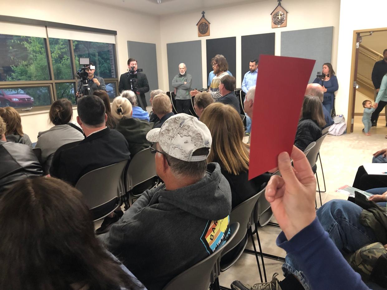 Residents held up red cards to show their opposition to the industrial rezoning of land at St. Joe Farm in Granger during the informational meeting at St. Pius Catholic School on Thursday, May 9, 2024.
