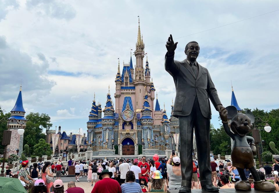 Guests gather for a performance in front of Cinderella Castle at Walt Disney World's Magic Kingdom.