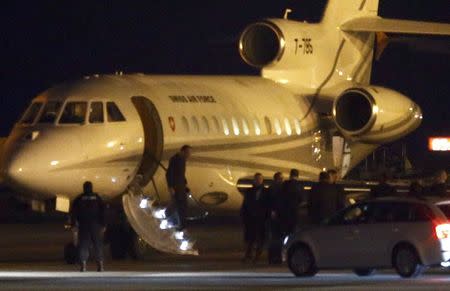 People walk off a plane carrying three Iranian-Americans, who left Tehran under a prisoner swap, after it landed at Cointrin airport in Geneva, Switzerland January 17, 2016. REUTERS/Denis Balibouse