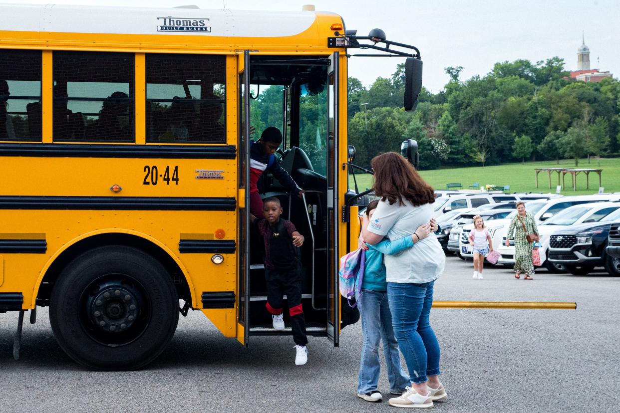 Christy Sharpe hugs a student as she gets off the bus during the first day back at Riverside Elementary School in Columbia, Tenn. on Monday, Aug. 7, 2023.