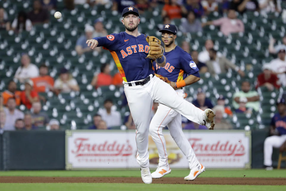 Houston Astros third baseman Alex Bregman, front, makes the play to first base in front of shortstop Jeremy Pena, back, on the grounder by Oakland Athletics' Max Schuemann during the fifth inning of a baseball game Wednesday, May 15, 2024, in Houston. (AP Photo/Michael Wyke)